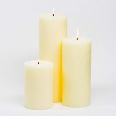 three white candles sitting next to each other