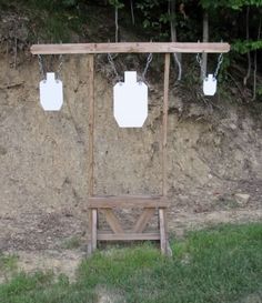 a wooden bench sitting in front of a wall with mason jars hanging from it's chains