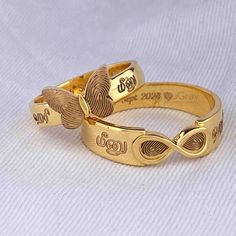 two gold rings that have been engraved on them