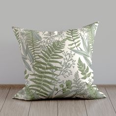 a green and white pillow sitting on top of a wooden floor