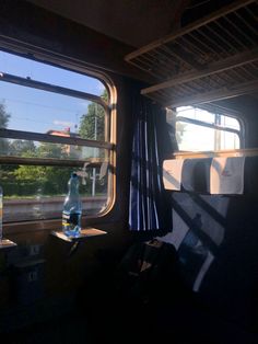 there is a bottle of water sitting on the window sill in this train car