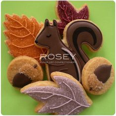 cookies decorated with icing and leaves on a green surface