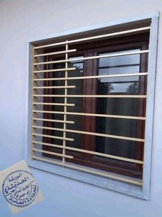 a window with wooden slats in front of it and a sticker next to it