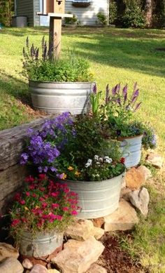 three flower pots sitting on top of a pile of rocks