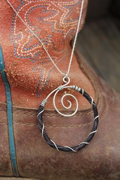 a pair of cowboy boots with a necklace on it