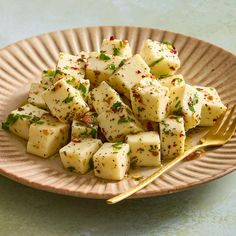 a plate full of tofu and chopsticks sitting on a blue table top