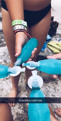 a woman is holding a blue water bottle in her right hand and another person has their hands on it