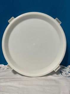 an empty white plate on a lace tablecloth