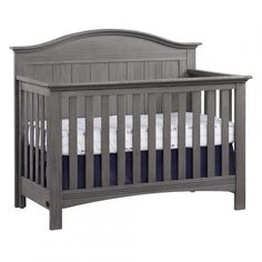 a gray crib with blue and white sheets on the bottom, in front of a white background