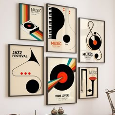 there are four posters on the wall in this living room, each with an abstract music theme