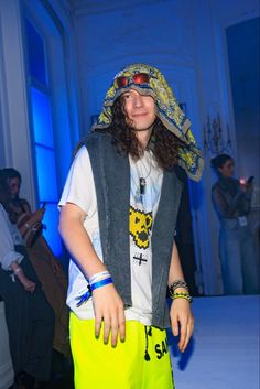 a young man wearing yellow shorts and a bandana on his head at a fashion show