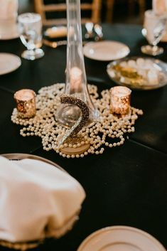 the table is set with candles, plates and napkins for an elegant wedding reception