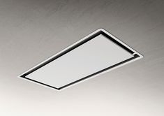 a white square light fixture suspended from the ceiling in a room with concrete walls and flooring