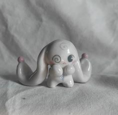 a small white elephant figurine sitting on top of a white cloth covered table