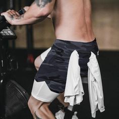 a shirtless man riding a stationary bike