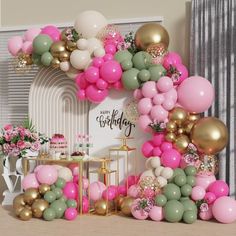 a birthday party with balloons, cake and flowers on the table in front of it