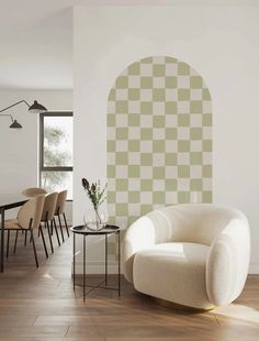 a living room filled with furniture and a white chair next to a wall covered in green squares