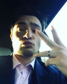 a man in a suit and tie holding his fingers up