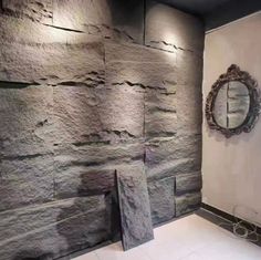 a large stone wall in a bathroom with a mirror on the wall and two sinks below it