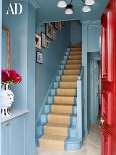 a hallway with blue walls and stairs painted in shades of red, white and blue