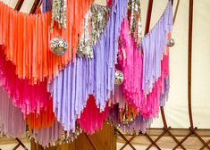 colorful streamers hanging from the ceiling in a yurt with mirrors and lights on it