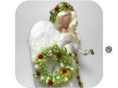 a crocheted angel holding a christmas wreath