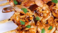 shrimp skewers with sauce and parsley on top