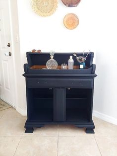 an old fashioned black piano in front of a wall with two baskets on it's back