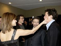 two men and one woman are touching each other's foreheads at an event