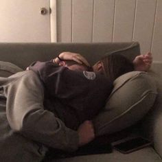 a man laying on top of a couch next to a woman