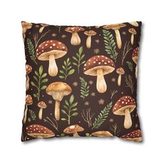 a brown pillow with mushrooms and leaves on the front, along with green plants in the back