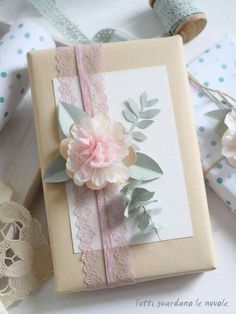 a close up of a greeting card on a table with some wrapping paper and flowers