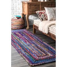 a living room with a couch and rugs on the floor