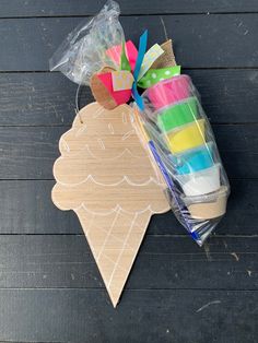 an ice cream cone shaped craft kit on a wooden table