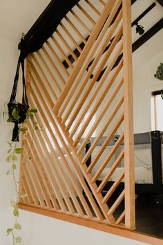 a room with a mirror and wooden slats on the wall next to a plant