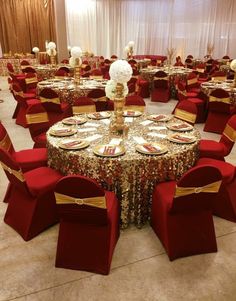 a banquet room with red chairs and gold table cloths