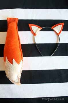 an orange and white fox head laying on top of a black and white striped bag