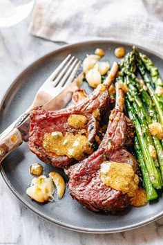 steak and asparagus on a plate with a fork