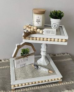 two tiered trays with plants and decorations on them, one is made out of wood