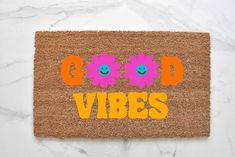 a door mat with the words good vibes written in orange and pink on it