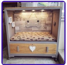 a dog bed with a welcome sign above it and paw prints on the bottom shelf