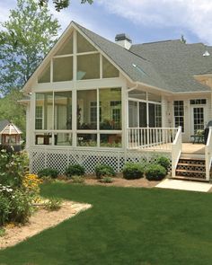 a large white house sitting on top of a lush green field