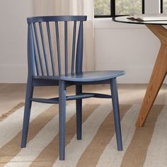 a blue wooden chair sitting in front of a table