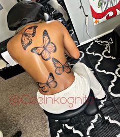 the back of a woman's body with butterflies on it