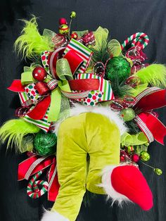 a christmas wreath with green, red and white decorations on it's face is shown