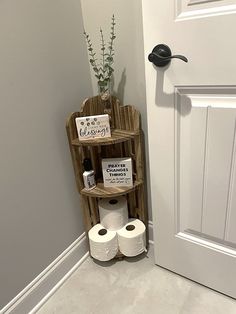 a bathroom with toilet paper and two rolls of toilet paper on the shelf next to the door