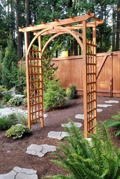 a wooden arbor in the middle of a garden