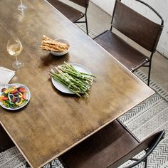 a wooden table with plates of food and glasses of wine