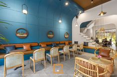 the interior of a restaurant with blue walls and wicker chairs, rattan tables and wooden benches