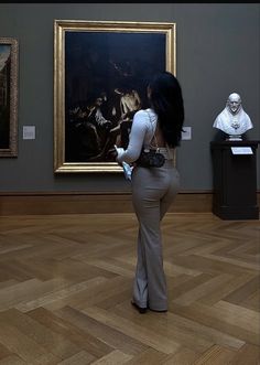 a woman is standing in front of a painting